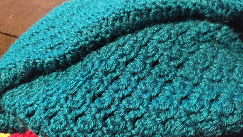 Close-up of crochet stitchwork that's part of a cardigan.