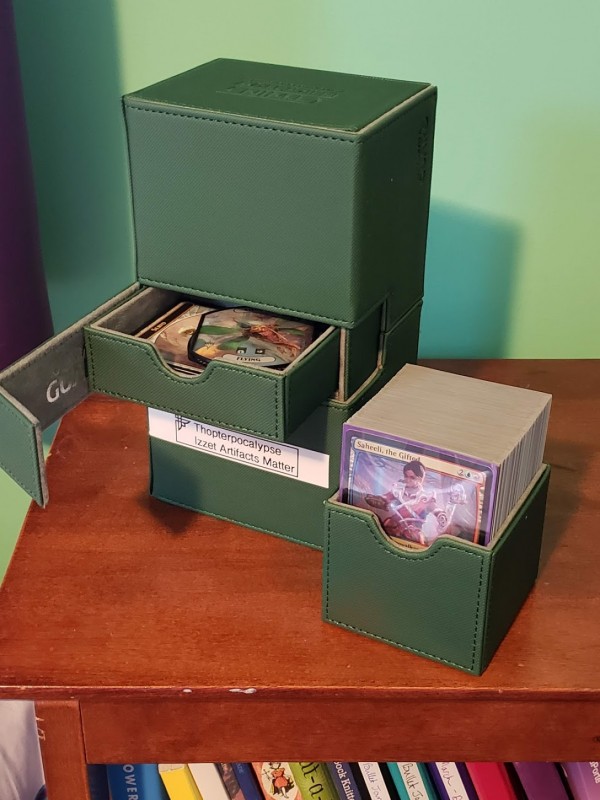 A green, heavy-duty Magic deck box. It holds two decks of cards and also has a tray to hold extra accessories.