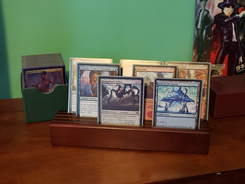 Wooden card holder, holding up seven Magic cards.