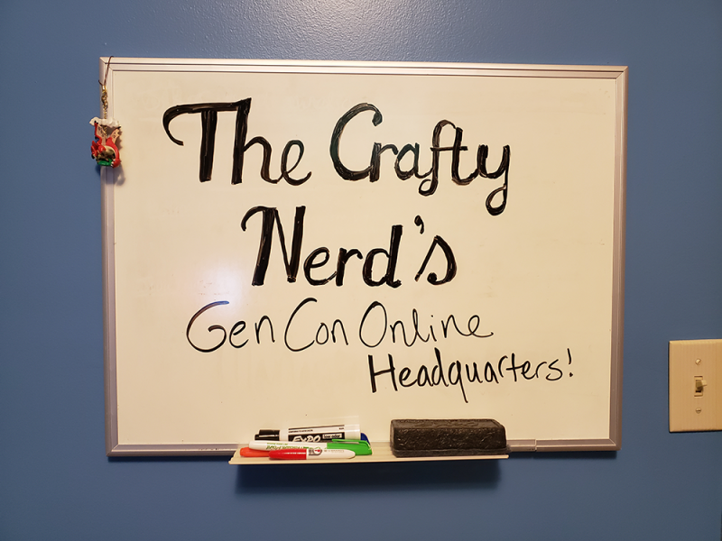 Whiteboard with the text 'The Crafty Nerd's Gen Con Headquarters!' written on it.